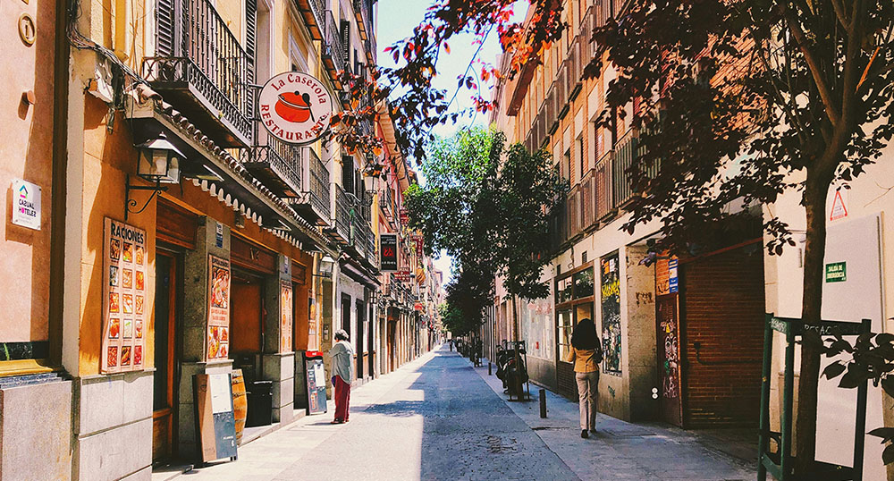 Narrow Street lined with shops and restaurants near Plaza Santa Barbara, Madrid, Spain